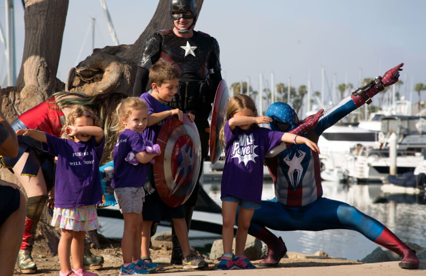 Kids and cosplay superhero at an MPS awareness event