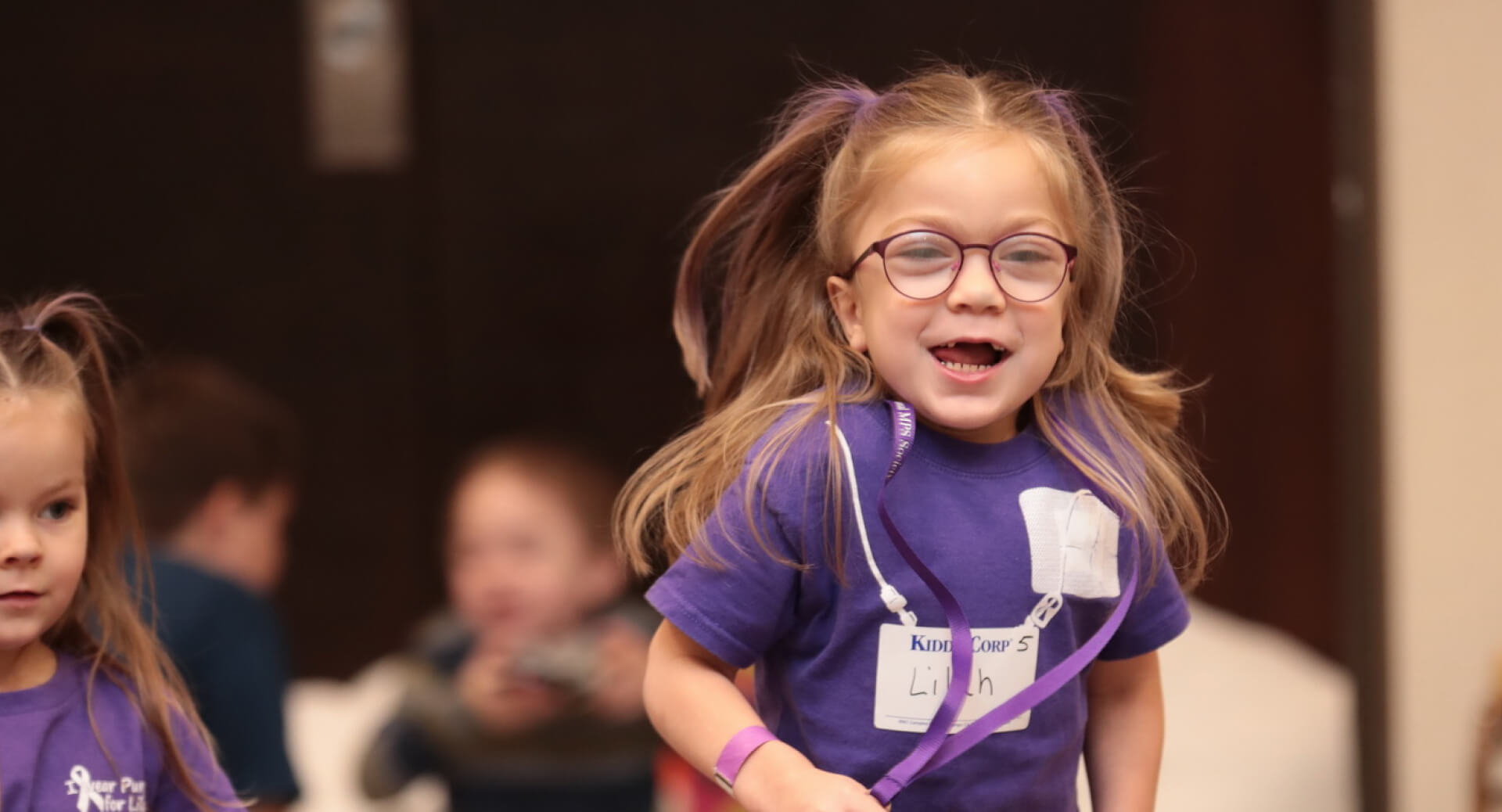 little girl running in a purple MPS awareness tshirt