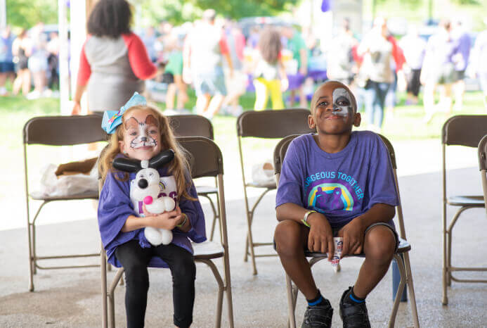 Two children with painted faces at an MPS awareness event