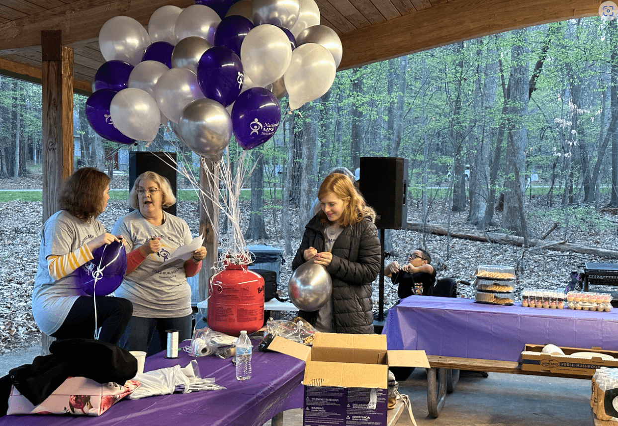 Volunteers blow up balloons at an MPS fundraiser