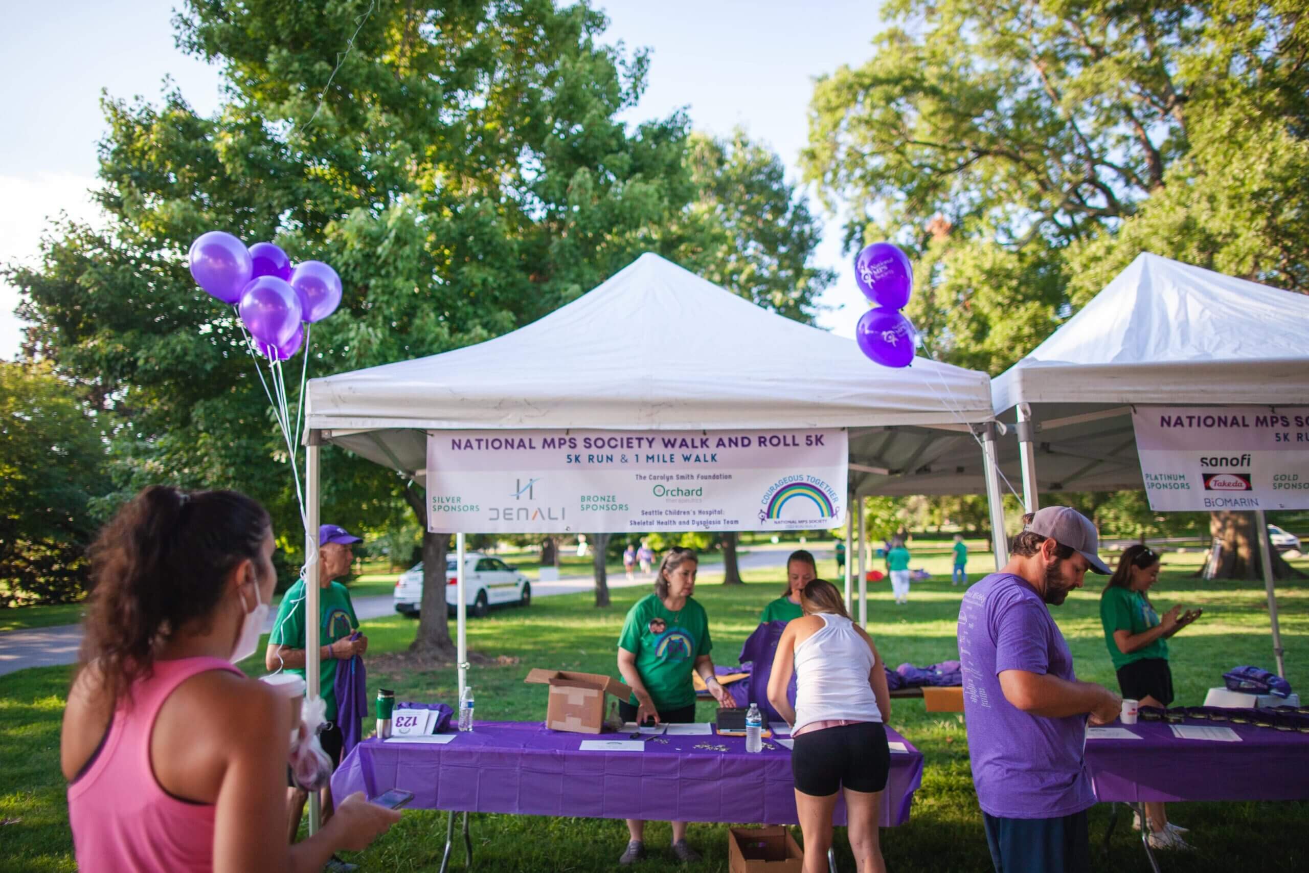 A booth with purple balloons at an MPS 5k event