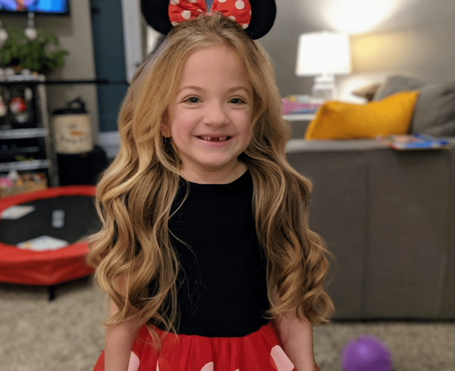 Girl in Minnie Mouse costume in her living room